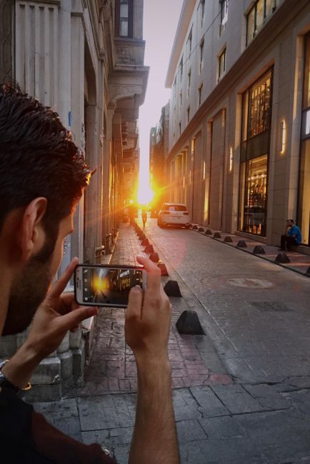 man taking a picture of someone down a street